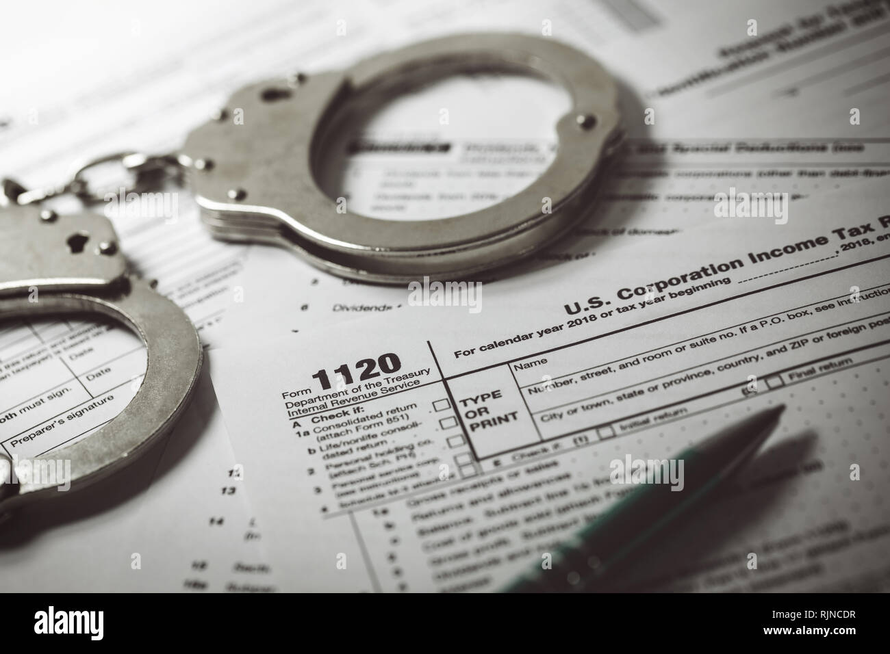Evasione fiscale concetto - modulo fiscale 1120 e manette Foto Stock