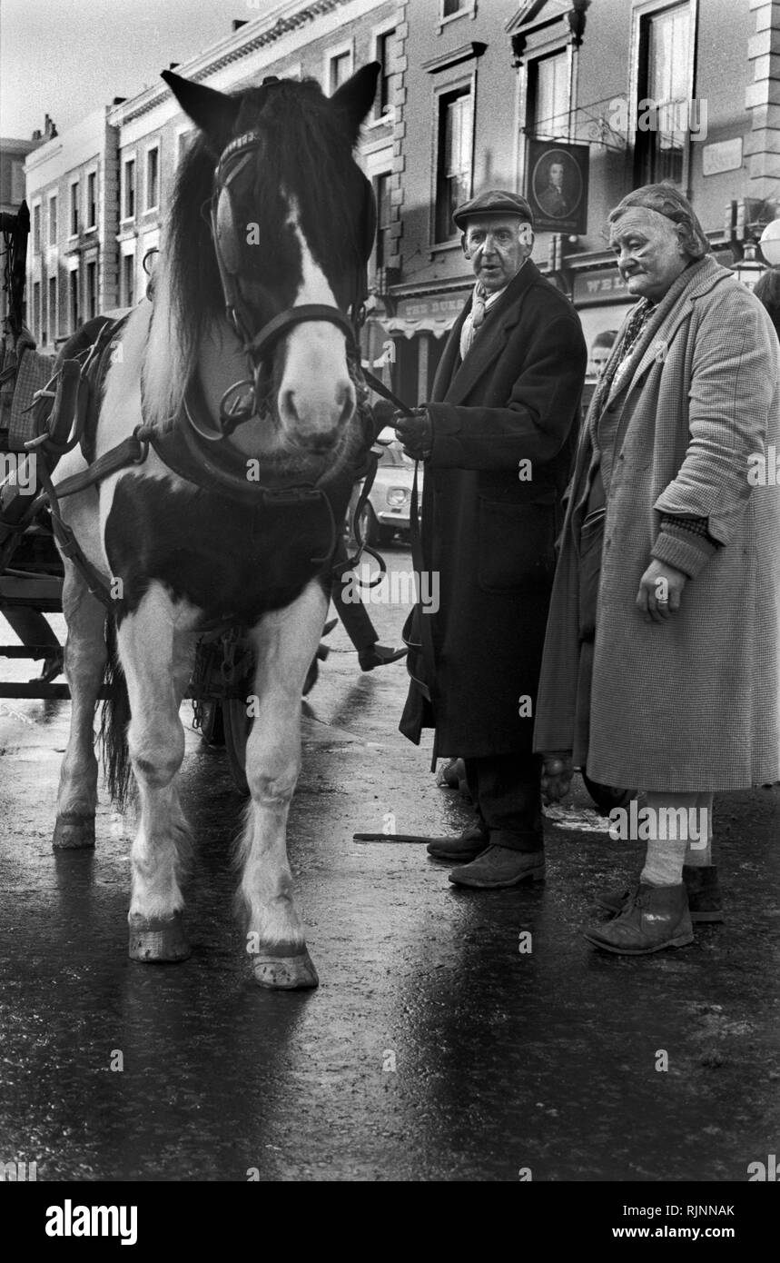 Rag and Bone Man con la moglie partner, il cavallo e il carro. Ha una bancarella che vende verdure fresche. Zona di Notting Hill nella zona ovest di Londra 1970. Raccolta dei rottami per il riciclaggio e il riciclo degli anni '1970 nel Regno Unito. HOMER SYKES Foto Stock
