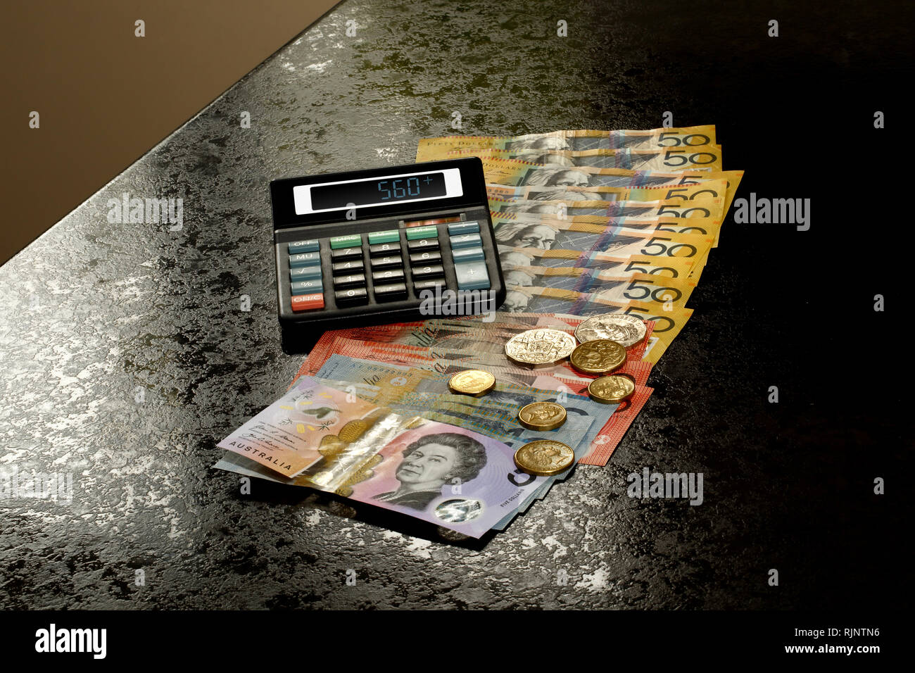 Dollari australiani e le monete in euro su un bancone cucina con la calcolatrice Foto Stock