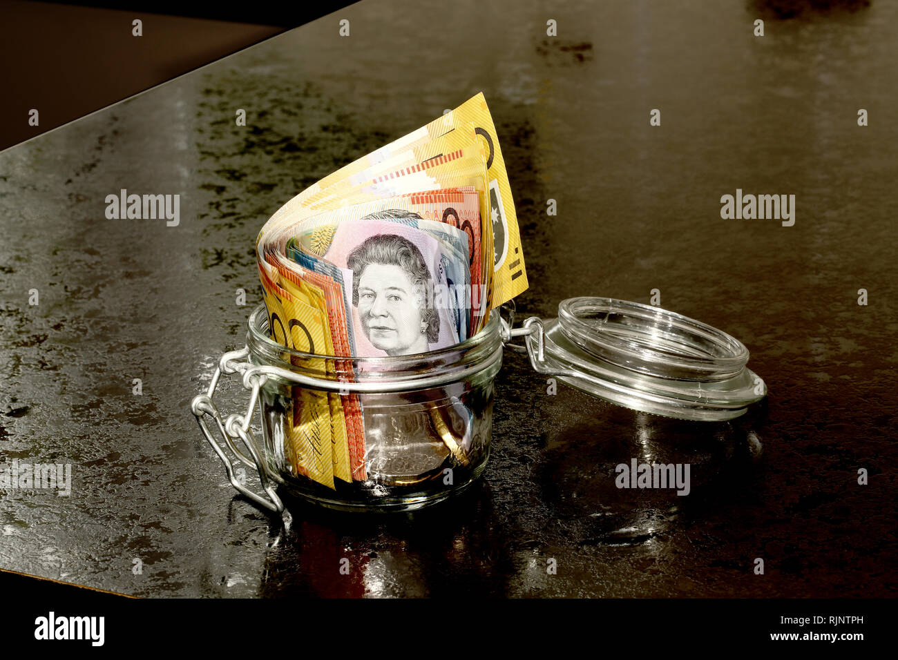 Dollari australiani in un vasetto di vetro su un banco di cucina Foto Stock