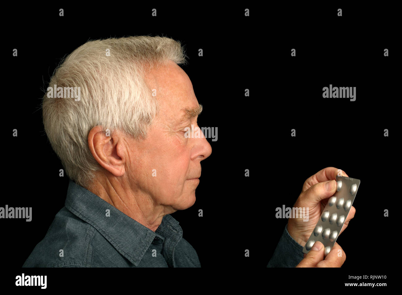 Un uomo nel suo 60's circa a prendere una compressa da una bolla pack Foto Stock