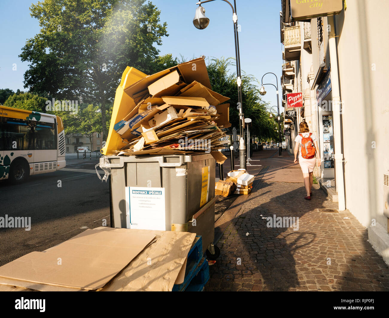 Chambery, Francia - Ago16, 2018: francese street in Chambery con i cassonetti pieni con carta scatole di cartone garbage donna due passi nelle vicinanze Foto Stock