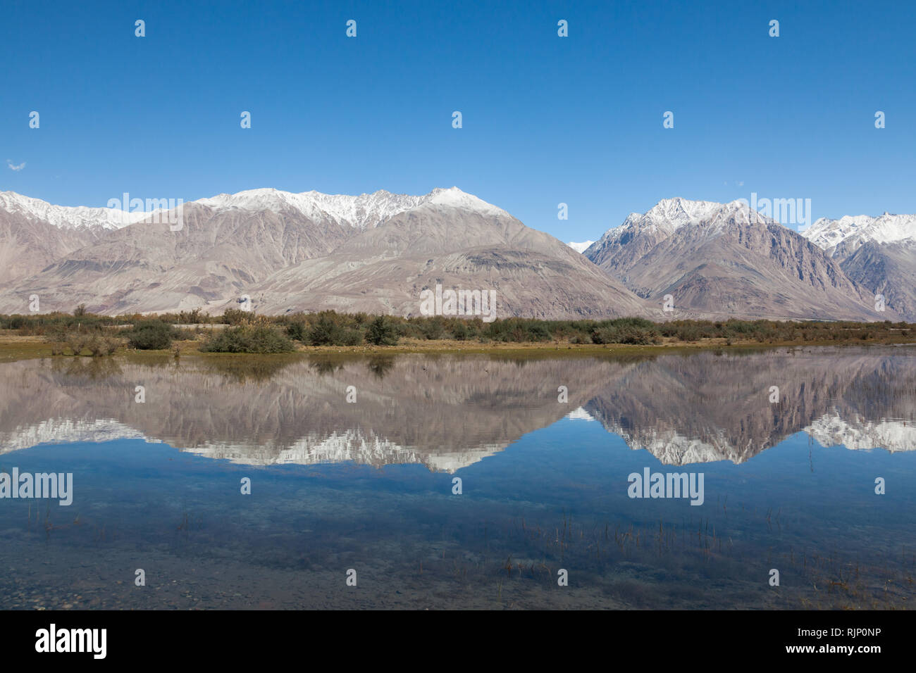 Paesaggio con montagne innevate che riflette nell'acqua, Valle di Nubra, Ladakh, Jammu e Kashmir India Foto Stock