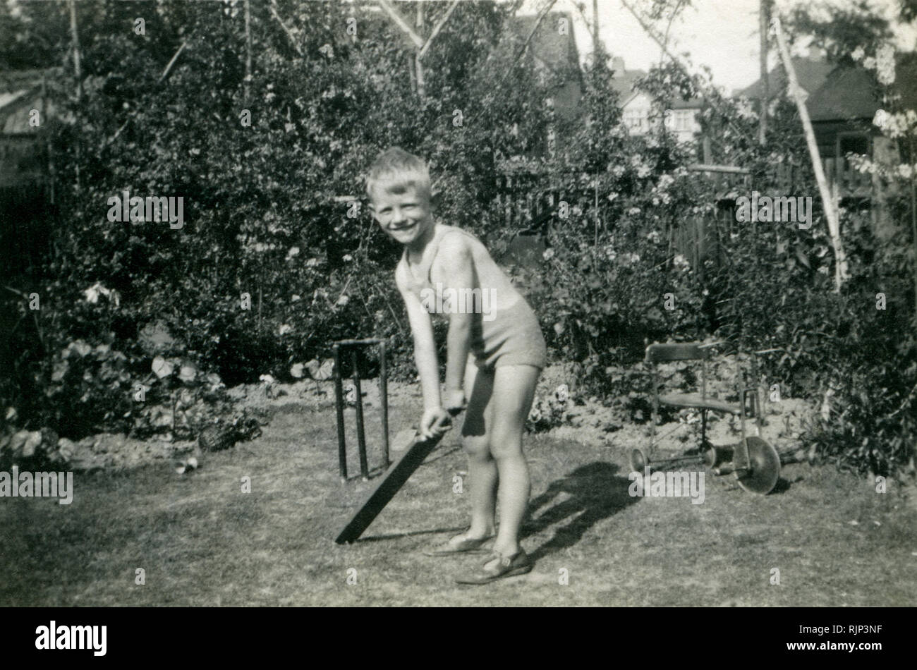 Ragazzo, quattro anni, giocare a cricket in suburban family garden, 1938 Foto Stock