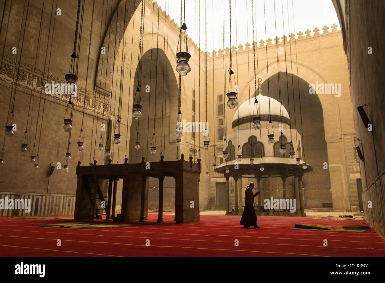 Una preghiera legge il Corano al Mosque-Madrassa del sultano Hassan nella città del Cairo, Egitto. Foto Stock