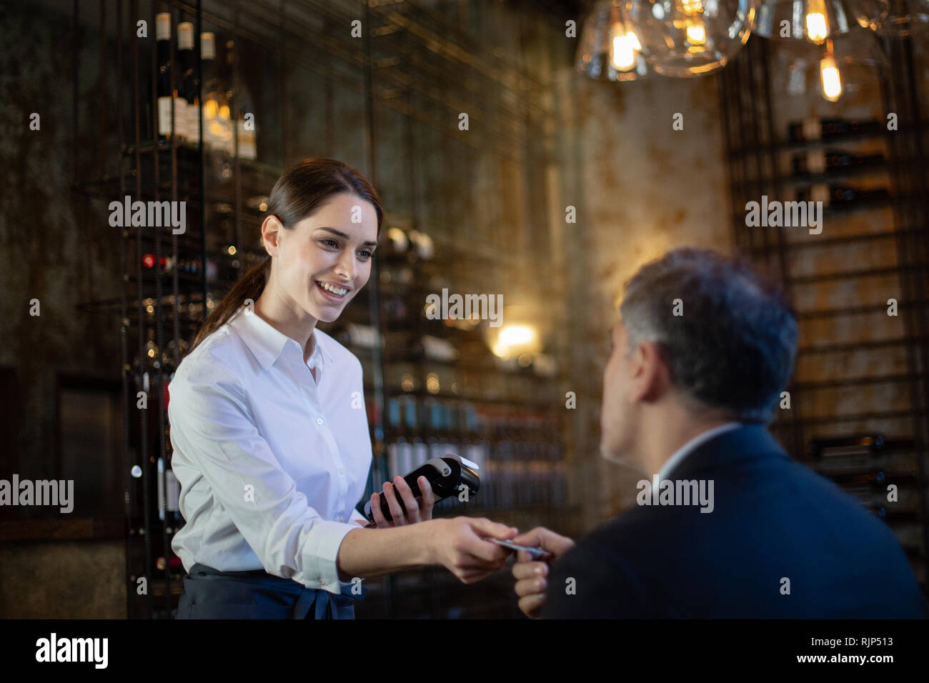 Cameriera di prendere il pagamento in un ristorante Foto Stock