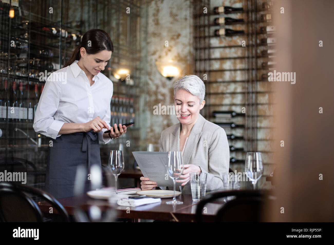 Imprenditrice di ordinare in un ristorante Foto Stock