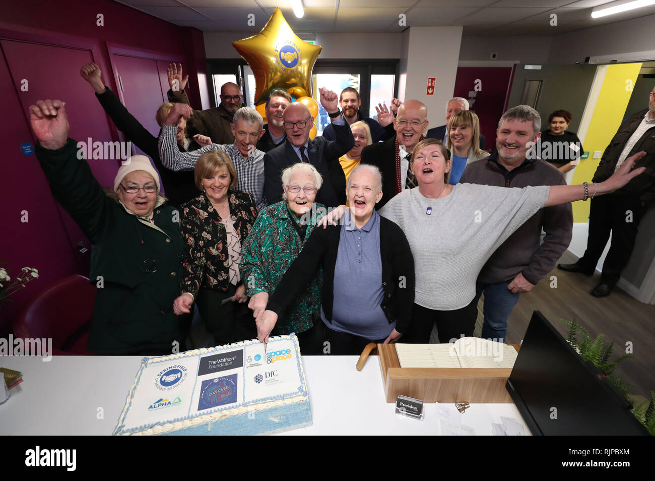 Mary Robinson e Ann Green tagliare la torta in apertura di Springfield associazione benefica della gioventù del club per le persone anziane in una volta un edificio abbandonato su Cupar Street, Belfast. Foto Stock