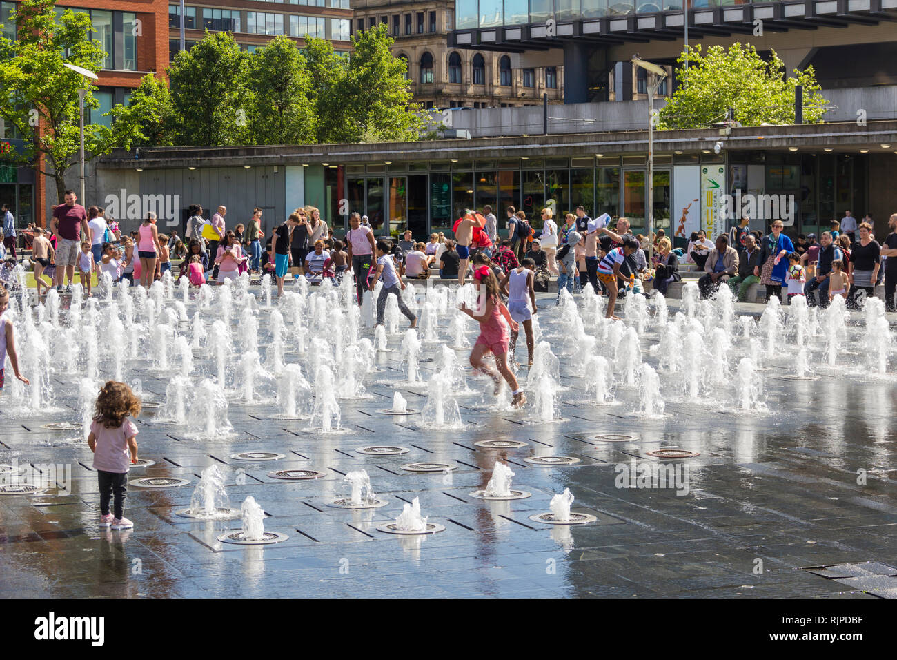 Bambini che giocano in acqua fontane in Piccadilly Gardens, Manchester in un caldo giorno d'estate. Foto Stock