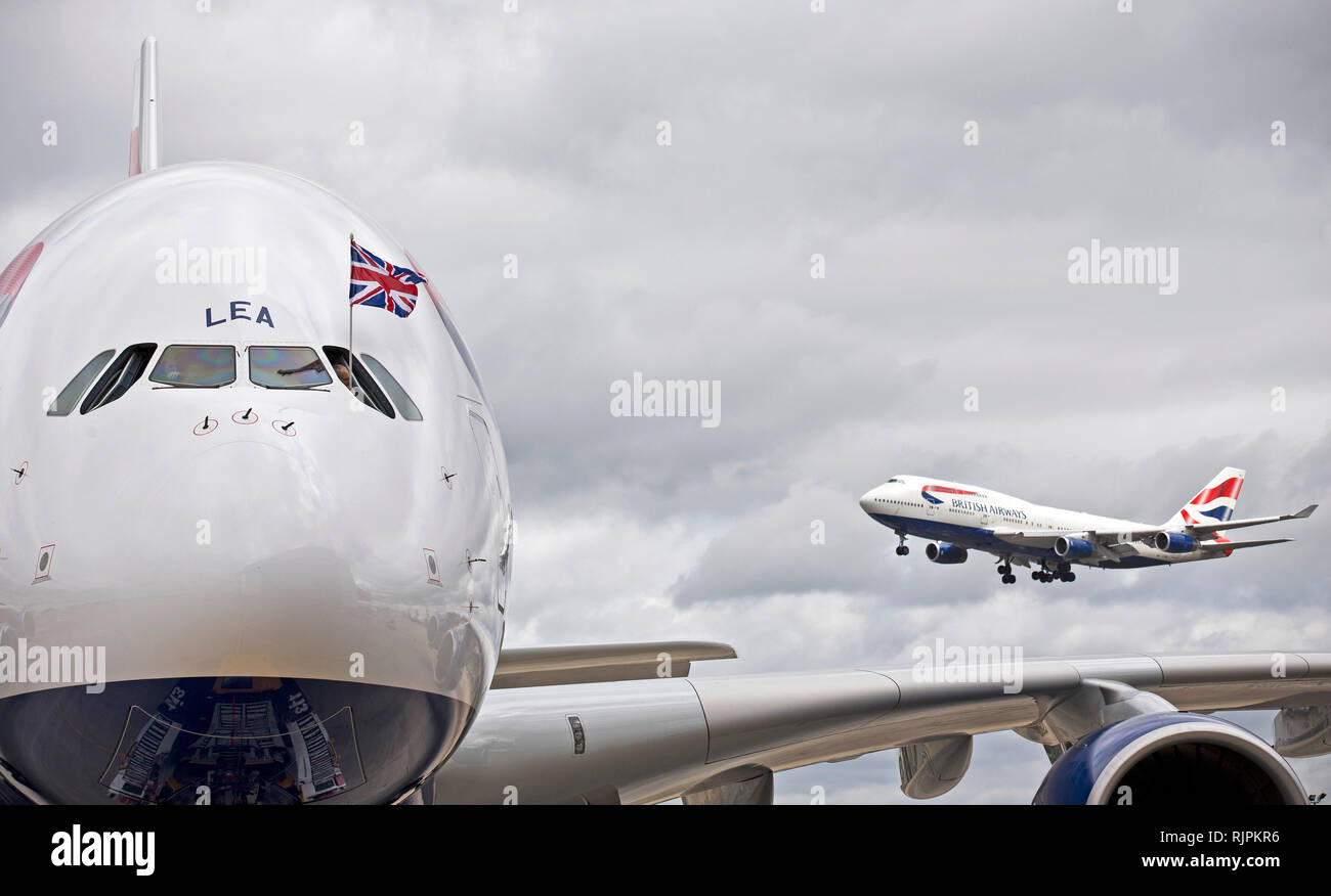 Un BA Boeing 747 terre (R) come un BA Airbus A380 (L) arriva presso l'aeroporto di Heathrow. Luglio 4, 2013. Foto Stock
