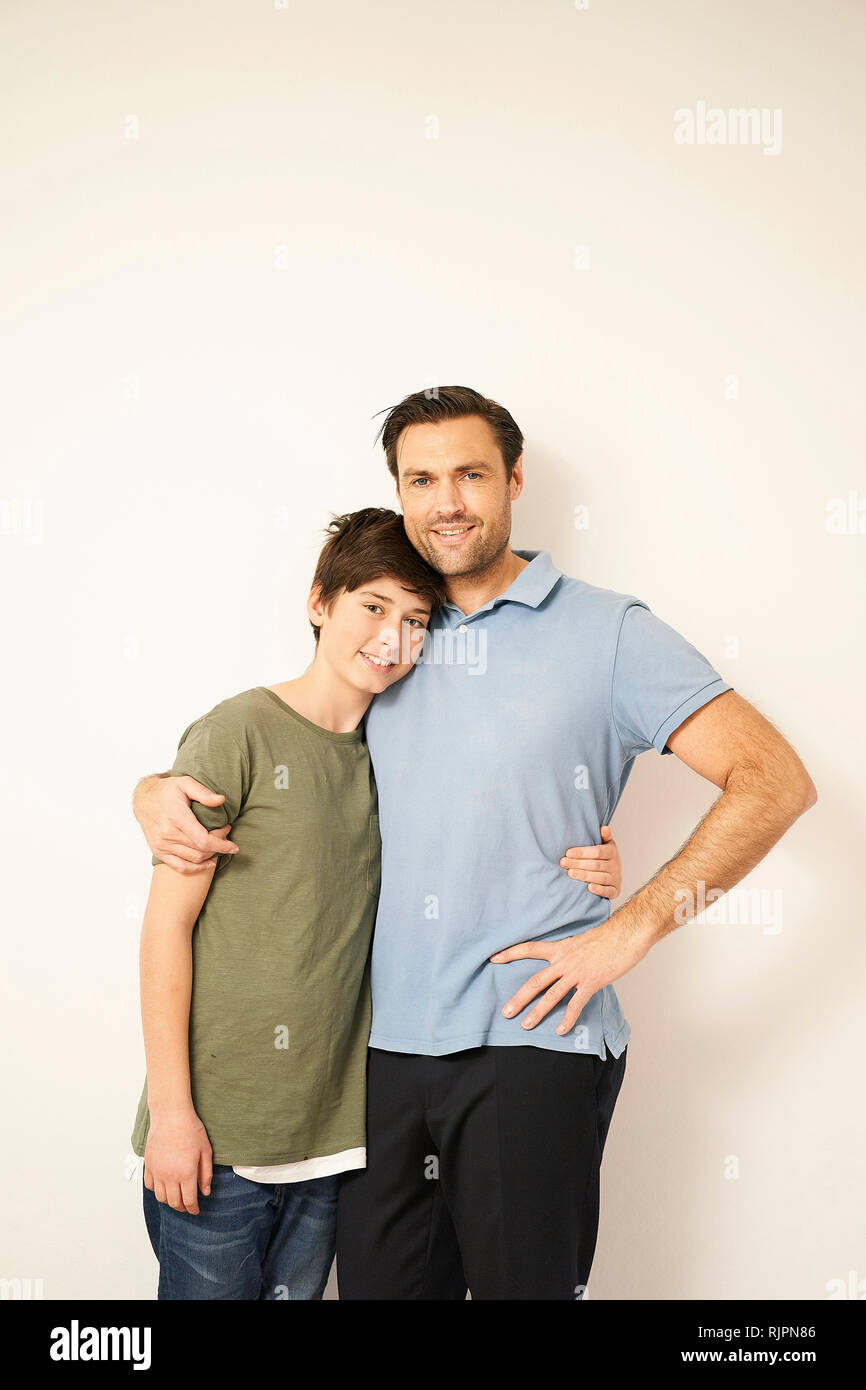 Ragazzo e padre con le braccia intorno a ciascun altro, ritratto Foto Stock