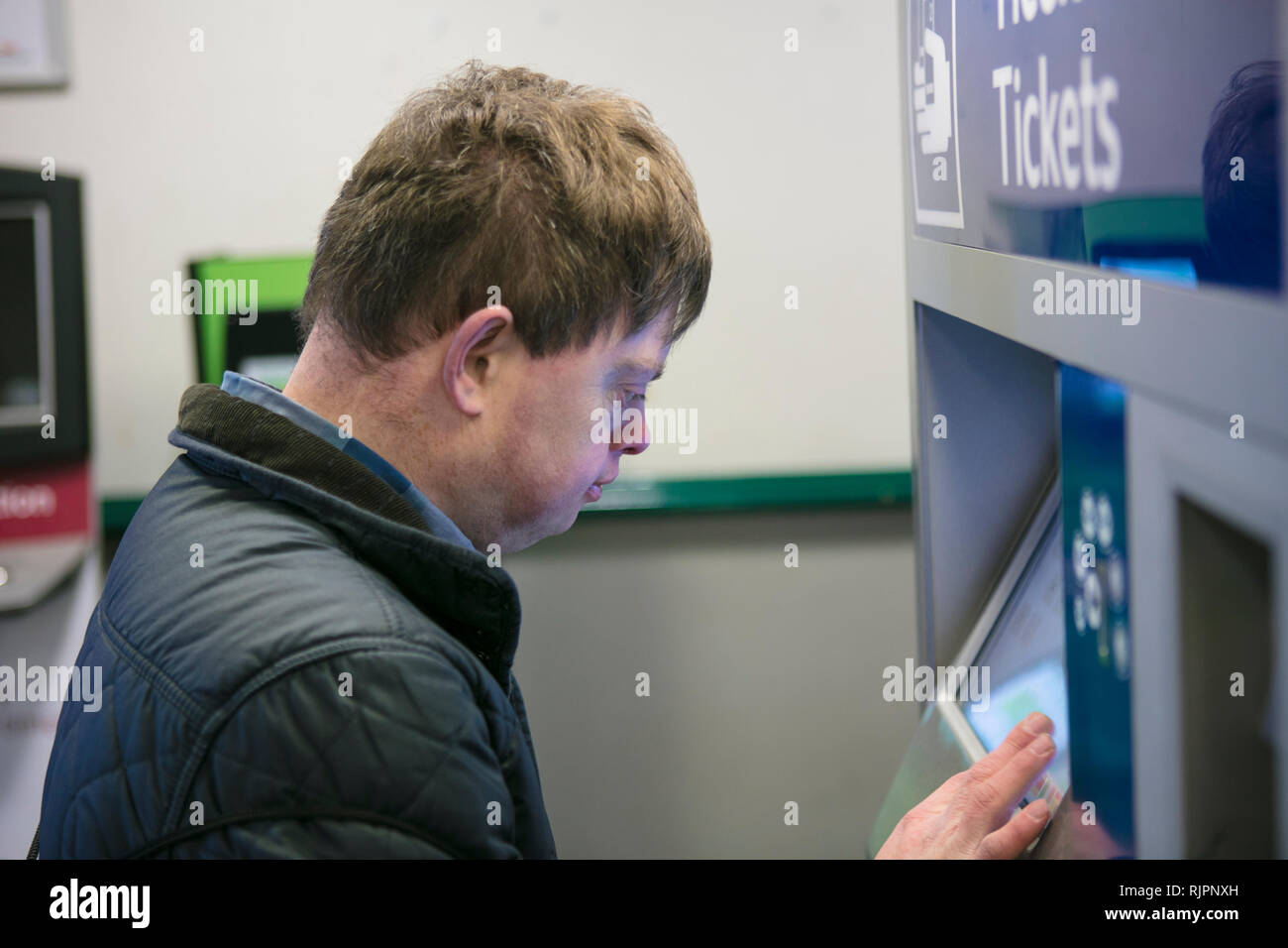 Uomo con la sindrome di down al biglietto del treno per macchina, Galway, Irlanda Foto Stock