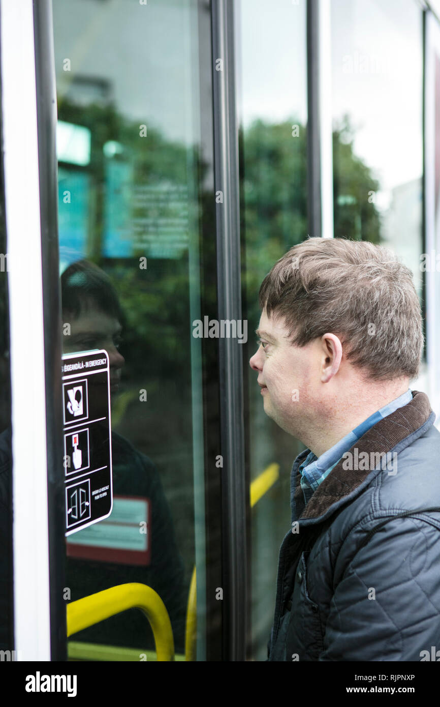 Uomo con la sindrome di down al di fuori della porta del treno, Galway, Irlanda Foto Stock