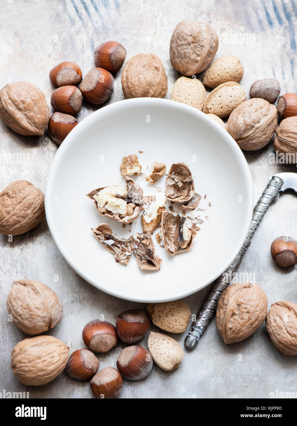 Noci e mandorle con guscio, nocciole, noce incrinato nel recipiente Foto Stock