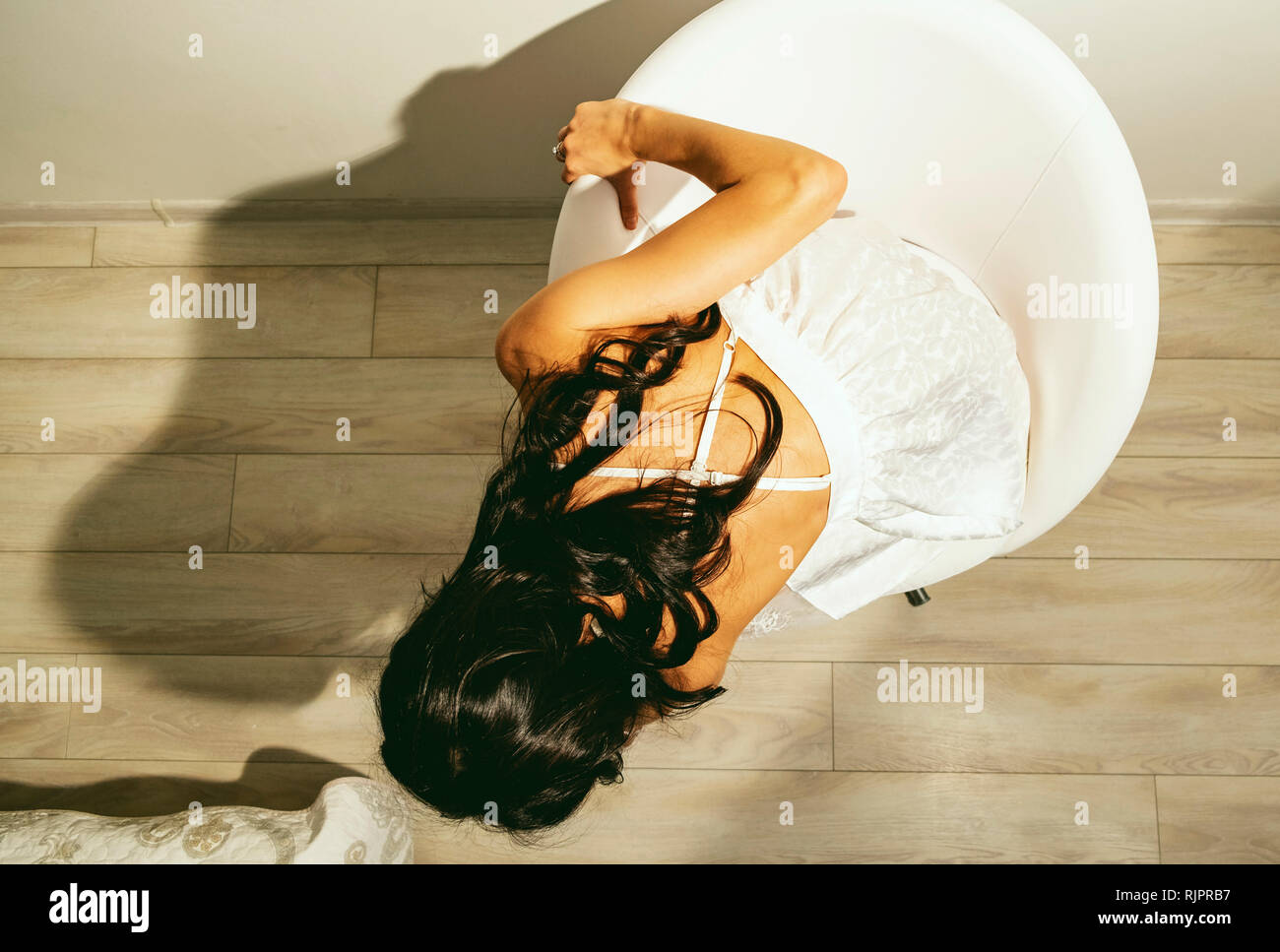 Donna in abiti estivi seduta Foto Stock