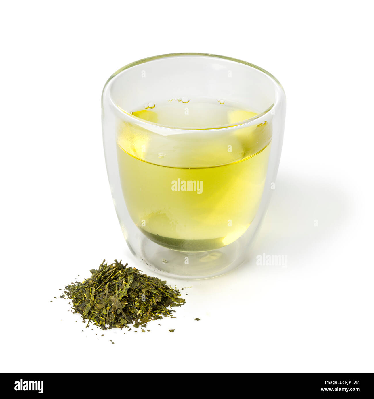 Bicchiere di vetro di tè verdi giapponesi e un mucchio di essiccato di foglie di tè verde isolato su sfondo bianco Foto Stock