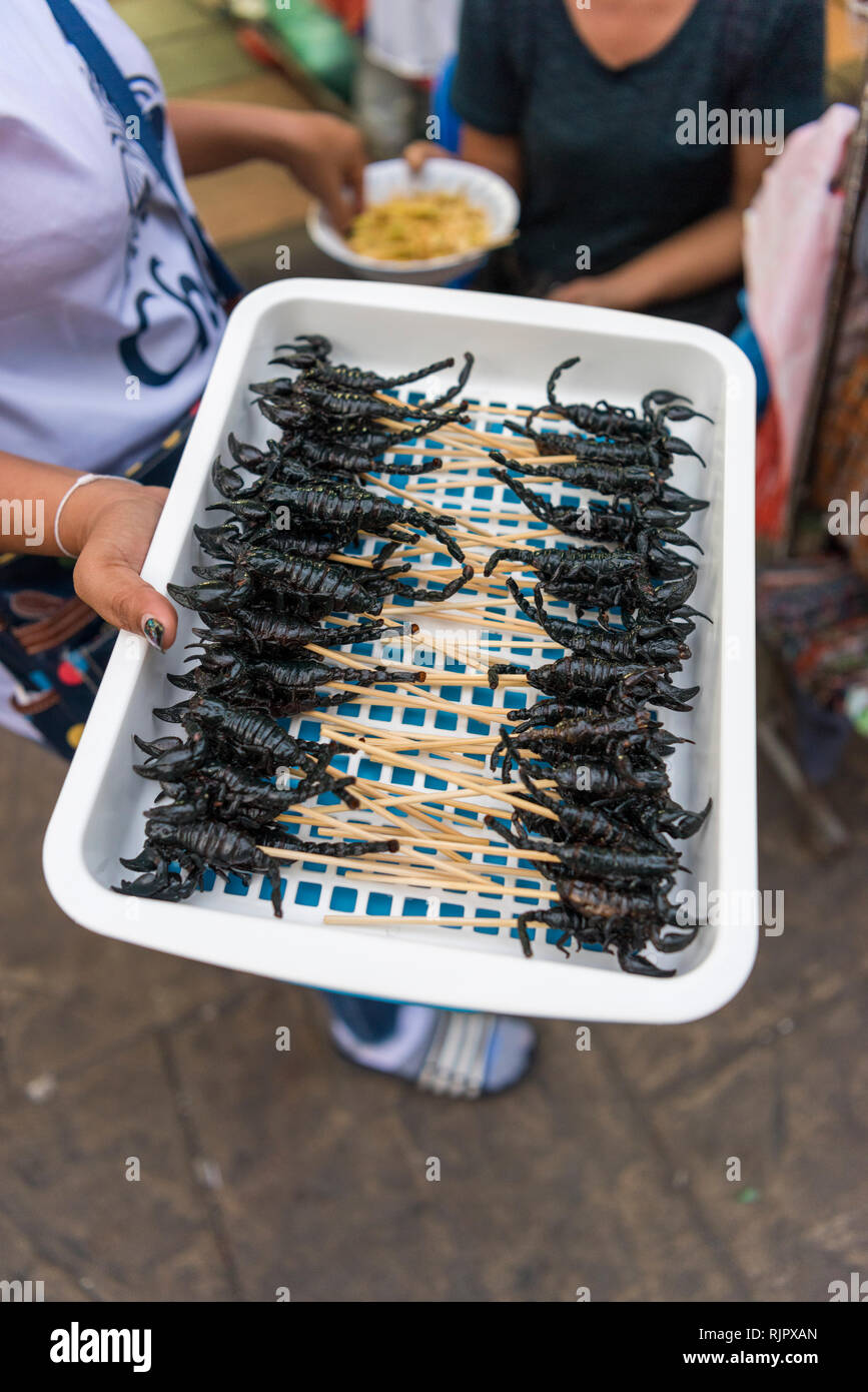 Cuocere gli scorpioni per vendita a mangiare il cibo da una strada di stallo alimentare a Bangkok in Tailandia Foto Stock