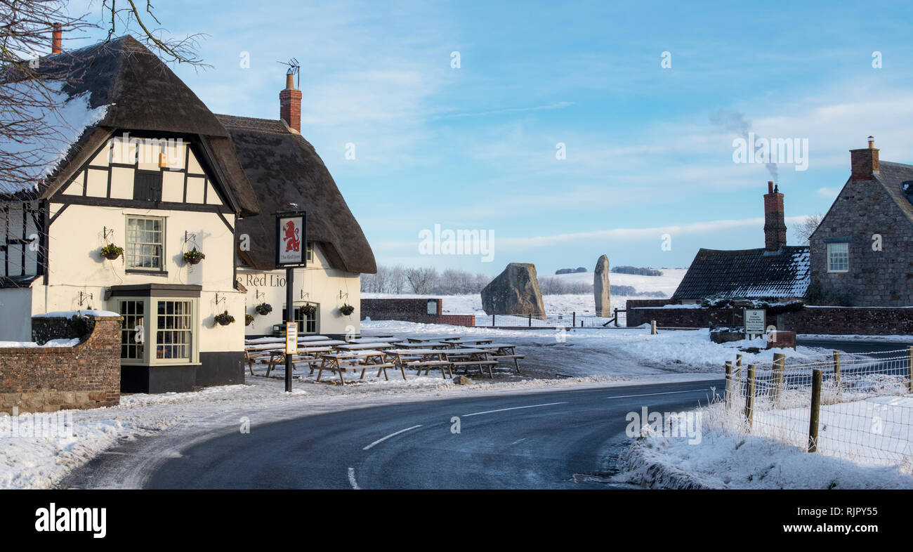 Il Pub Red Lion nella neve in Avebury, Wiltshire, Inghilterra. Vista panoramica Foto Stock