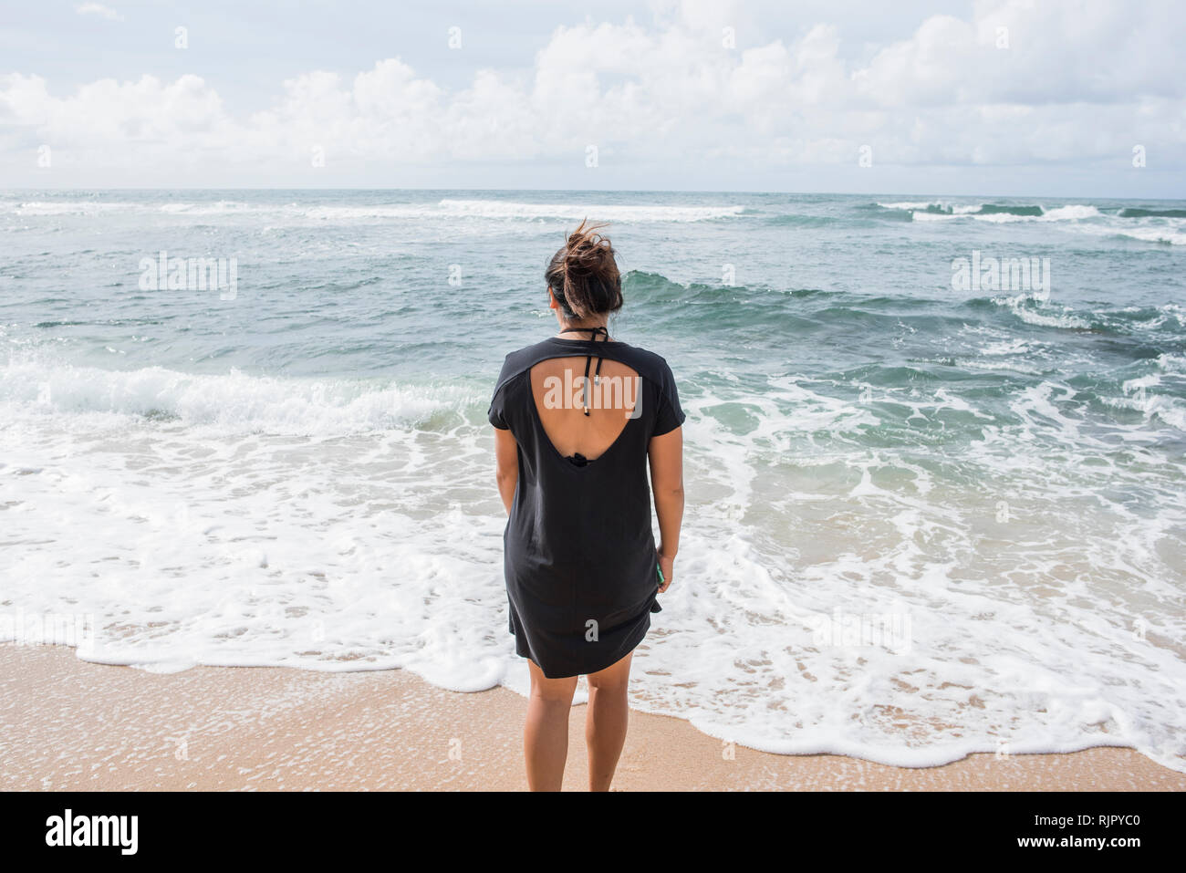 Donna che guarda al mare, Kapaa Beach, Kauai, Hawaii Foto Stock