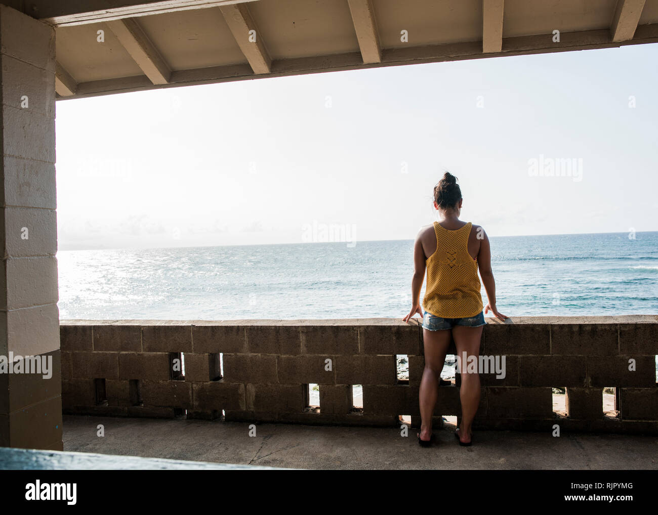 Donna che guarda al mare dal balcone, Hookipa Beach, Maui, Hawaii Foto Stock