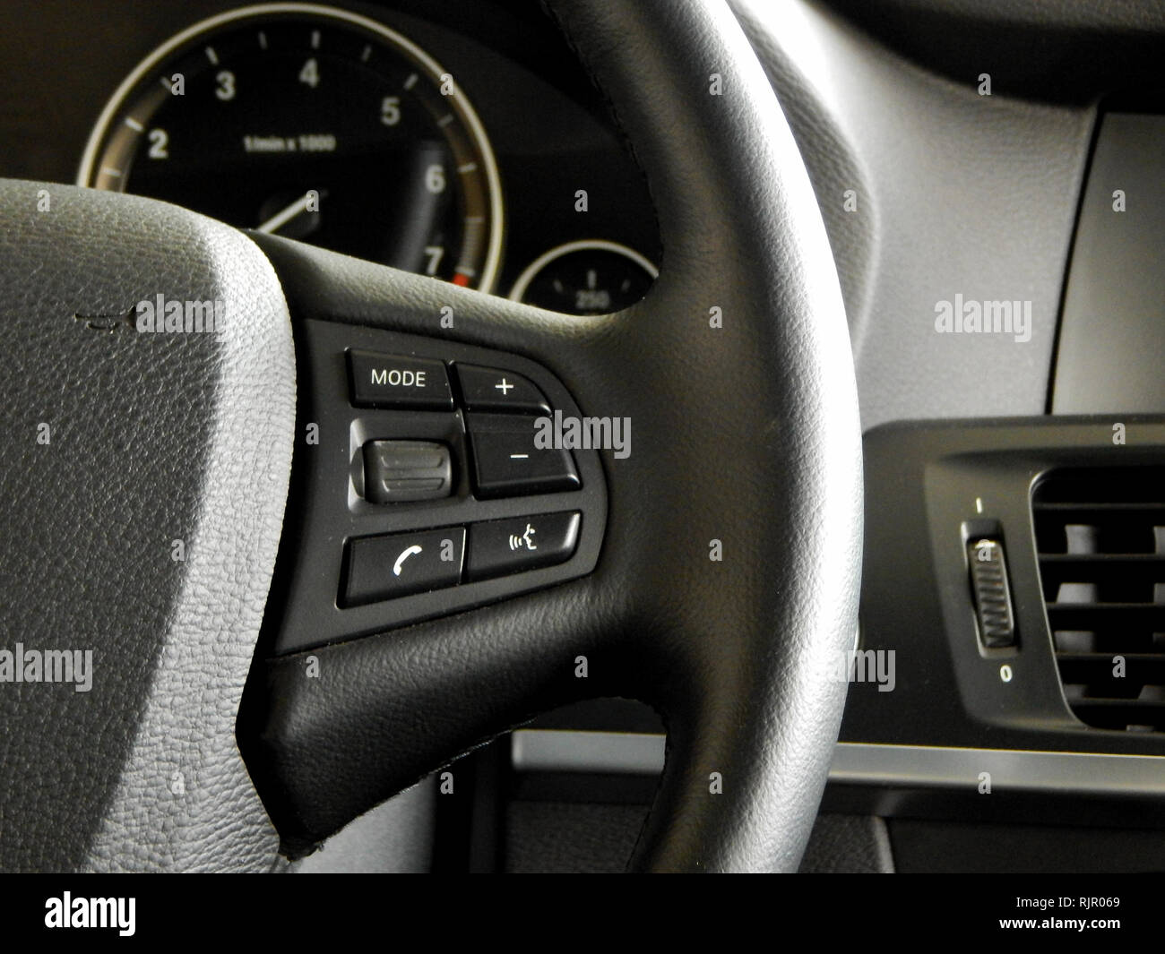 I pulsanti di comando e interfaccia di comando vocale sul volante all'interno di un automobile Foto Stock
