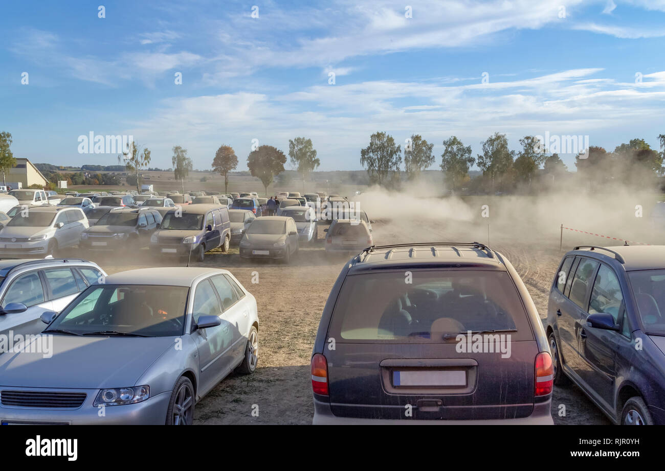 Parcheggio polveroso scenario dello spazio su un campo compreso un sacco di polvere auto coperti in serata nella Germania meridionale Foto Stock