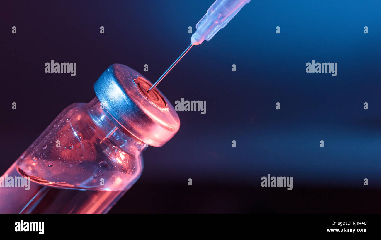 Bottiglia in vetro con vaccino e la siringa per iniezione. Concetto foto circa la minaccia di malattie virali o la tossicodipendenza. Foto Stock