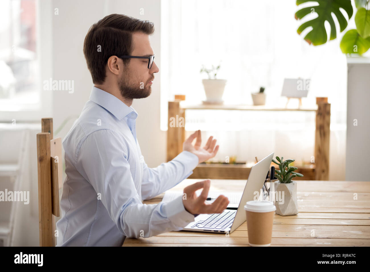 Calma imprenditore meditando sul posto di lavoro a praticare yoga concentrandosi sulla concentrazione Foto Stock