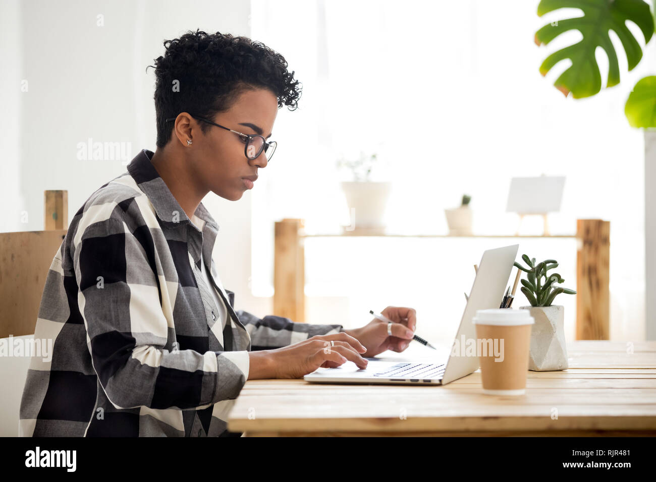 African American giovane donna utilizzando laptop lavorare o studiare online Foto Stock