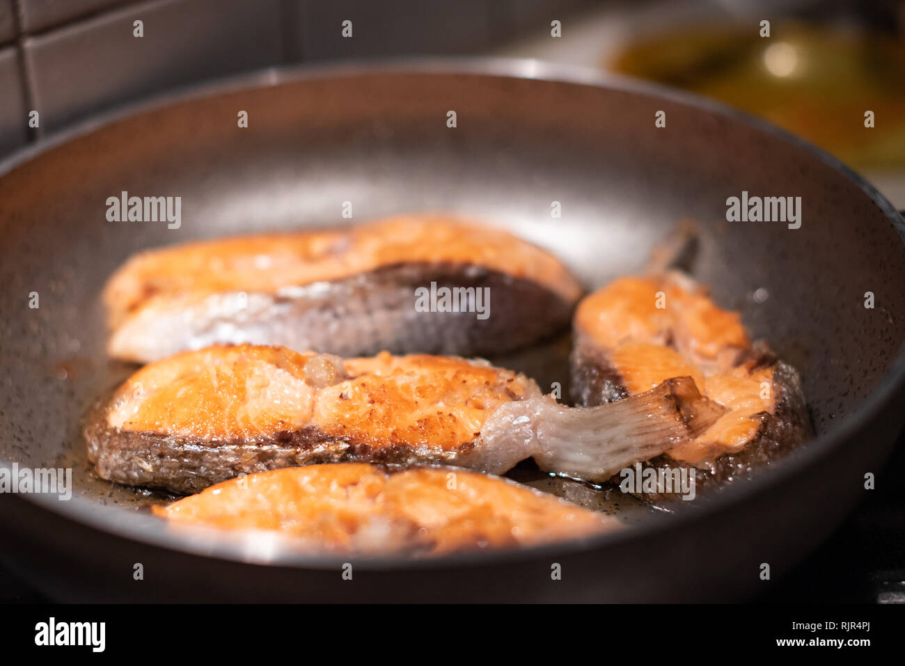 Salmone fritto in padella. La cottura di filetti di salmone. Foto Stock