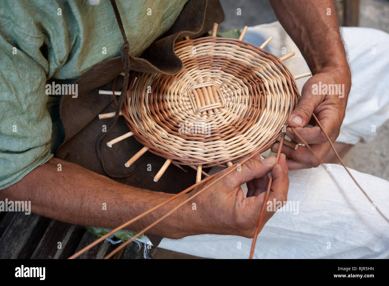 L'artigiano costruisce un cestello tessitura i rami di salici Foto Stock