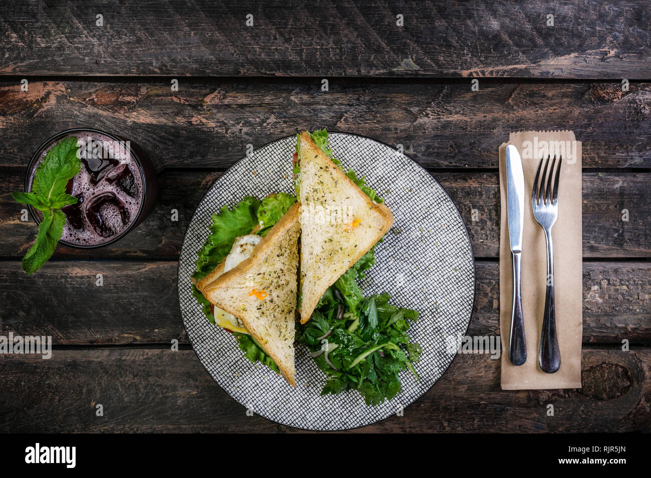 Sandwich di Pollo e le verdure su una piastra di ceramica. Servita con posateria e limonata fresca. Vista superiore Foto Stock