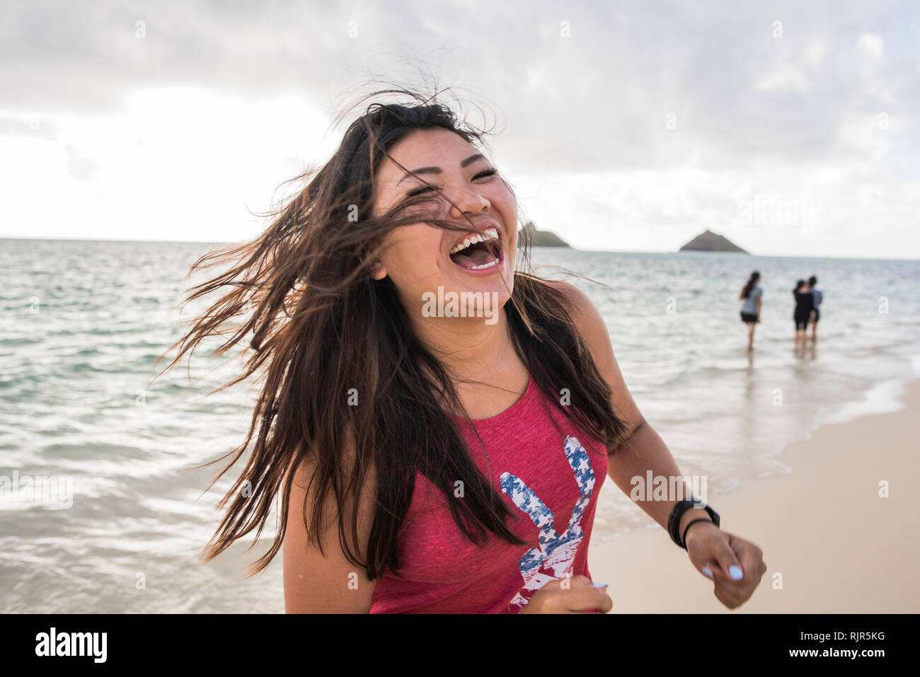 Donna capelli oscillanti, Lanikai Beach, Oahu, Hawaii Foto Stock