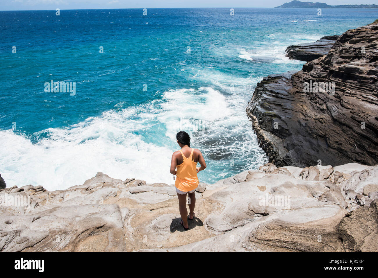Donna esplorare la costa rocciosa, sputare grotte, Oahu, Hawaii Foto Stock