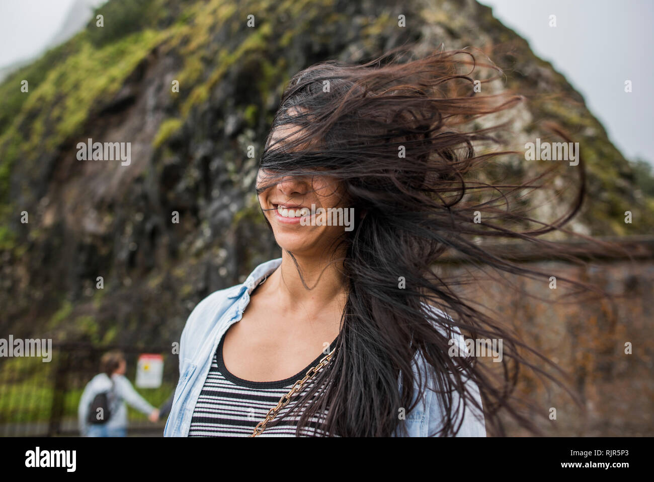 Donna con capelli spazzate dal vento, nu'uanu Pali Lookout, Oahu, Hawaii Foto Stock