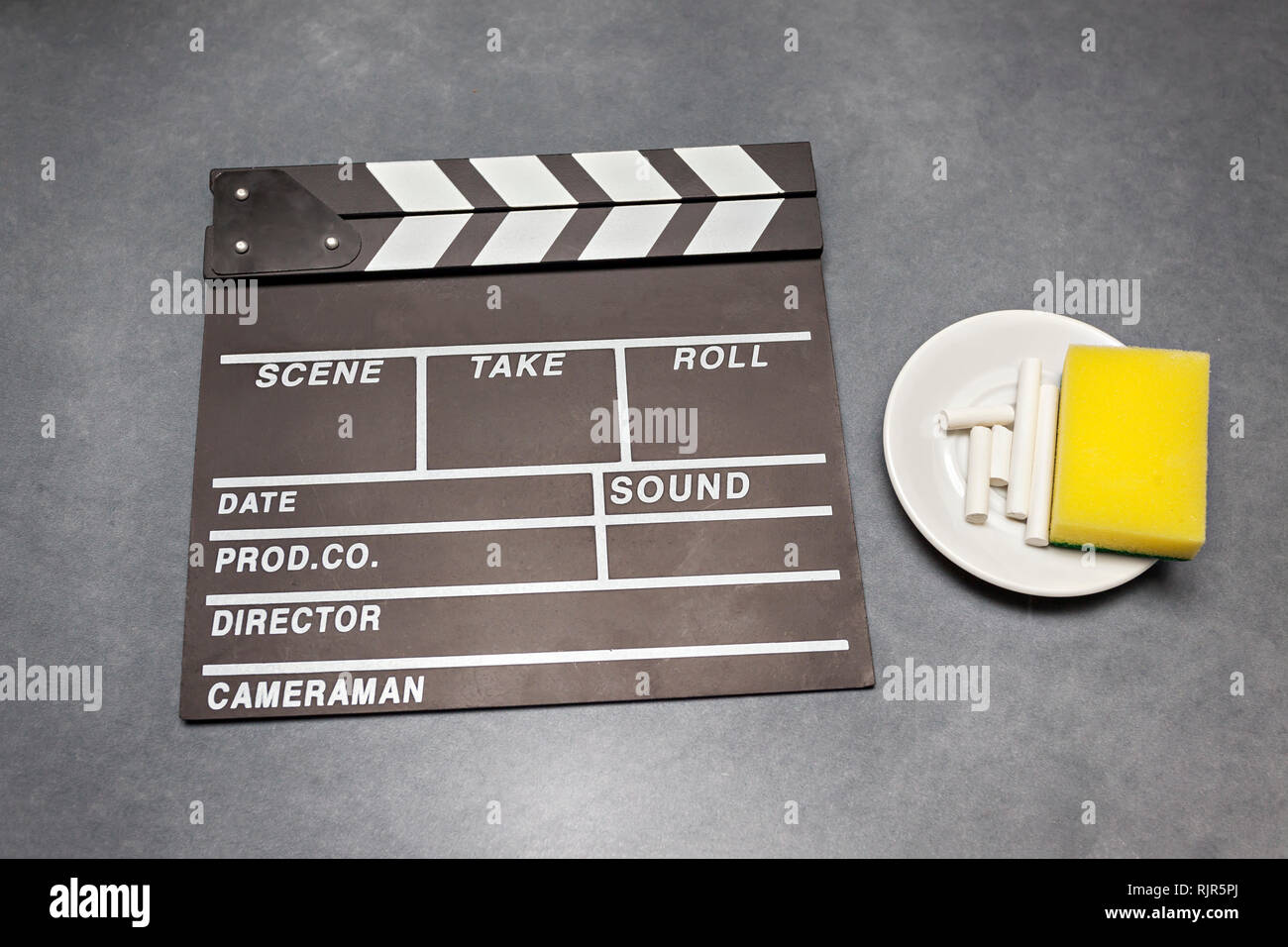 Filmato battaglio board con gesso e spugna su sfondo grigio - film, cinema e video il concetto di fotografia Foto Stock