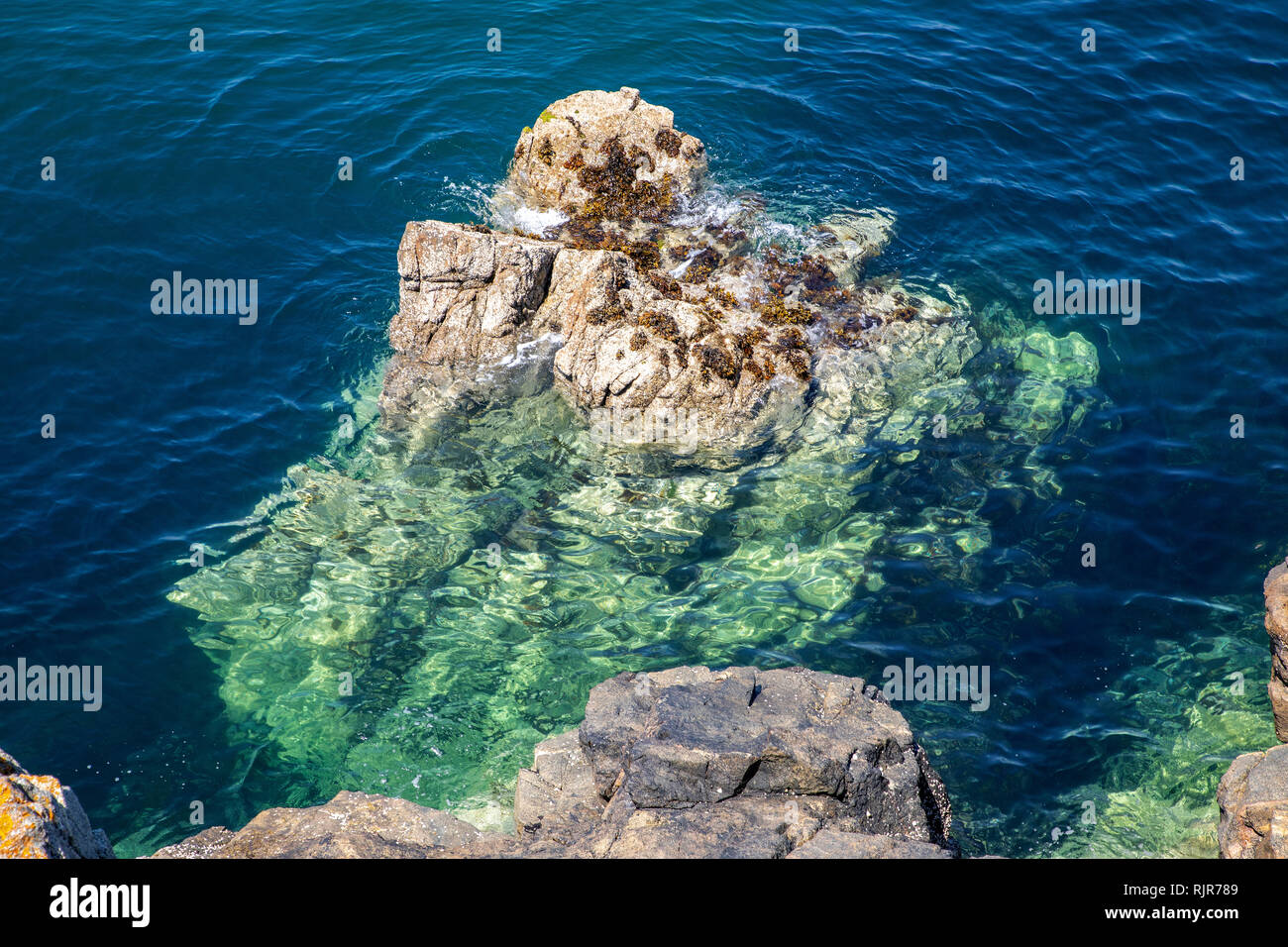 Un affioramento di roccia nei pressi di Roselle Pont su Alderney mostra il mare cristallino dell'acqua. Foto Stock
