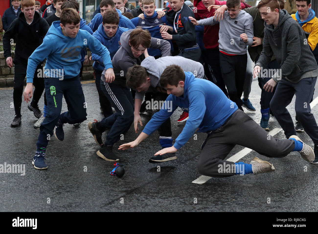 I ragazzi si tuffano sulla palla di pelle durante l'evento annuale 'Fastern's e'en Hand Baa' sulla High Street di Jedburgh, ai confini scozzesi. Foto Stock