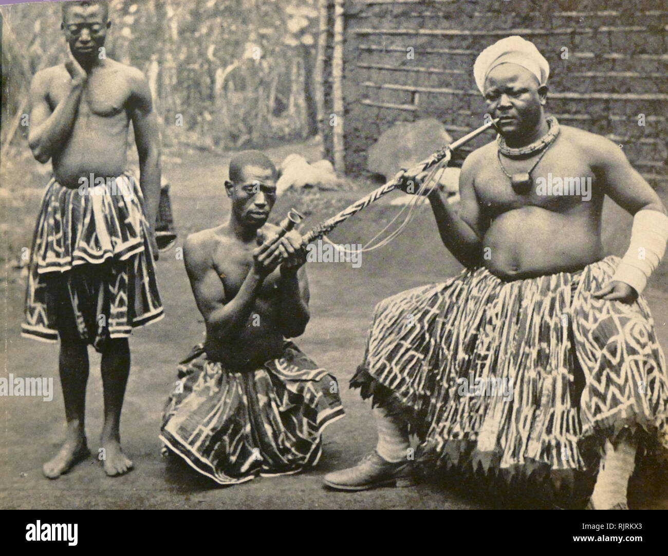 Leader tribale con tubazione tenuta da un servo; Camerun, Africa occidentale circa 1935 Foto Stock