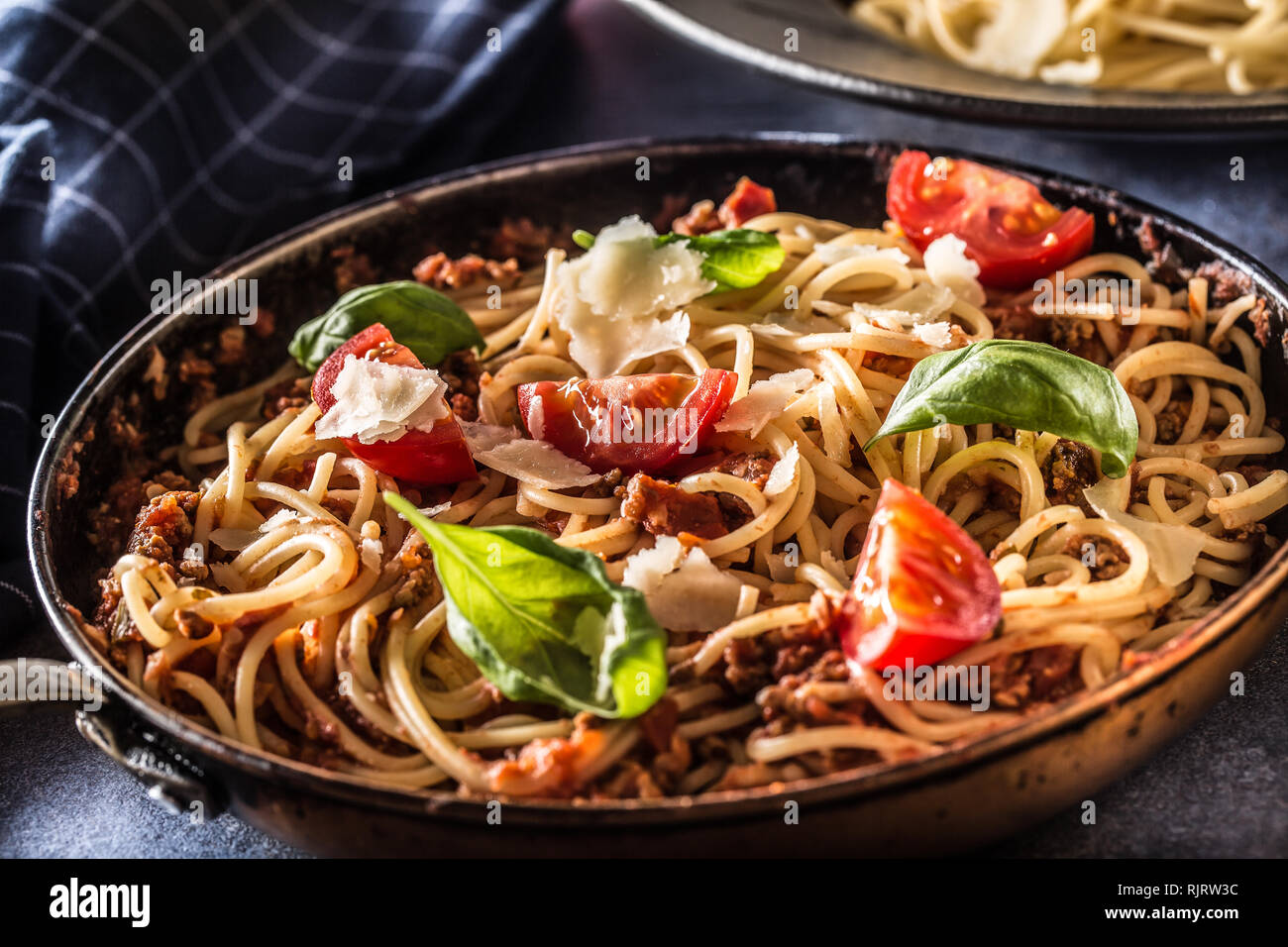 La pasta italiana spaghetti alla bolognese vecchia in padella con pomodori formaggio parmigiano e basilico Foto Stock