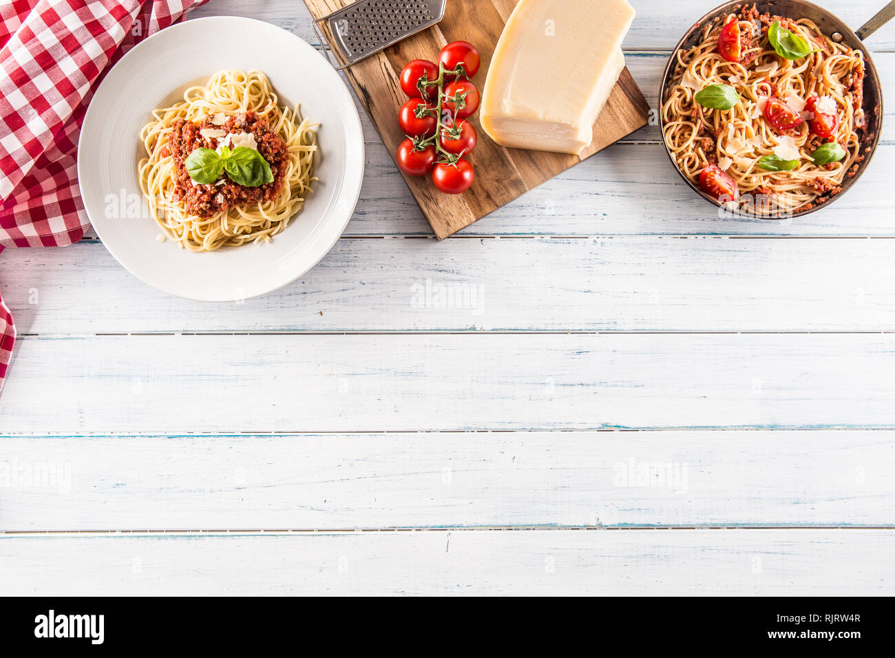 Parte superiore di vista la pasta italiana spaghetti alla bolognese in piastra e pan con pomodori e basilico Foto Stock