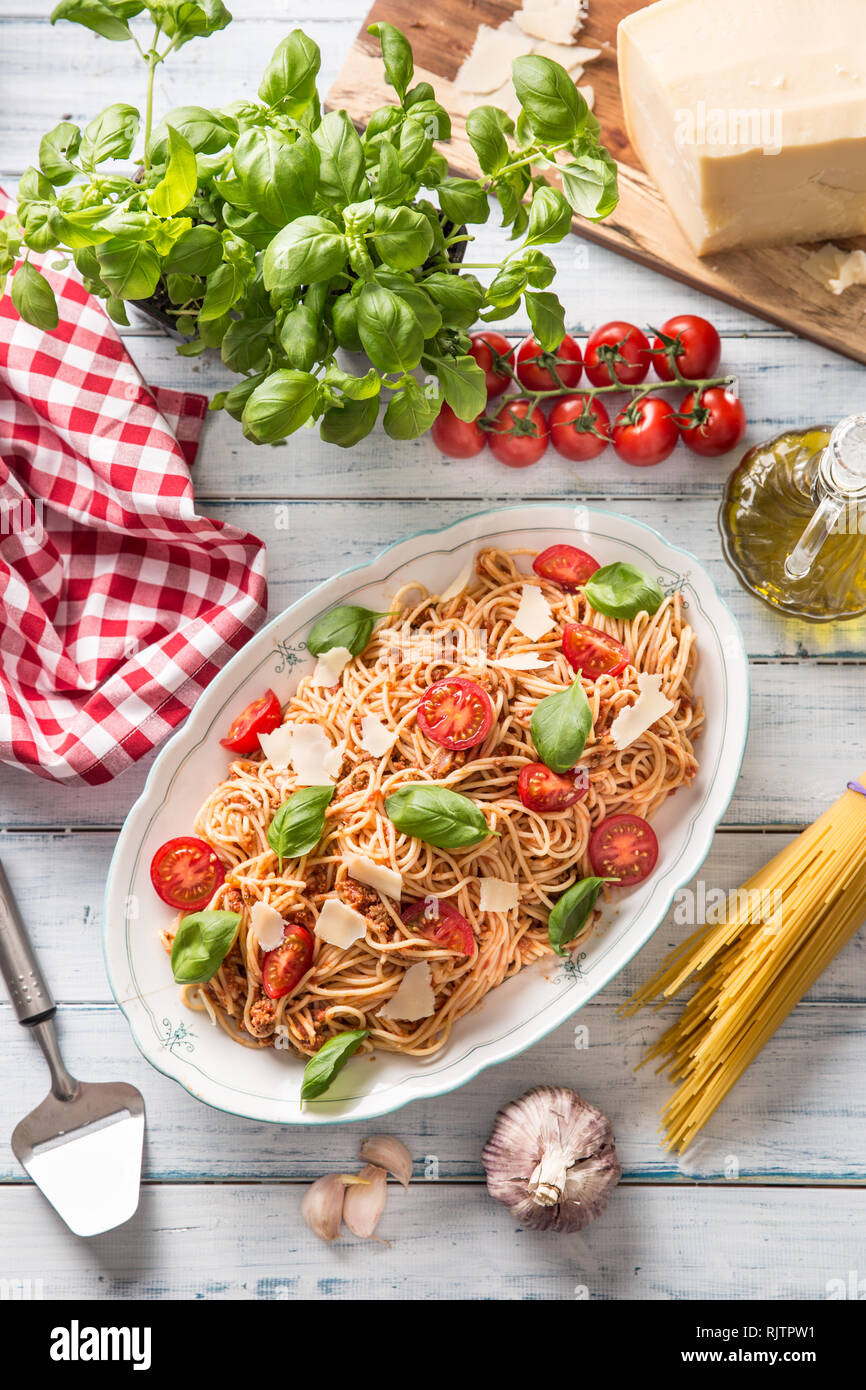 La pasta italiana spaghetti alla bolognese in bianco ciotola con pomodori formaggio parmigiano e basilico Foto Stock