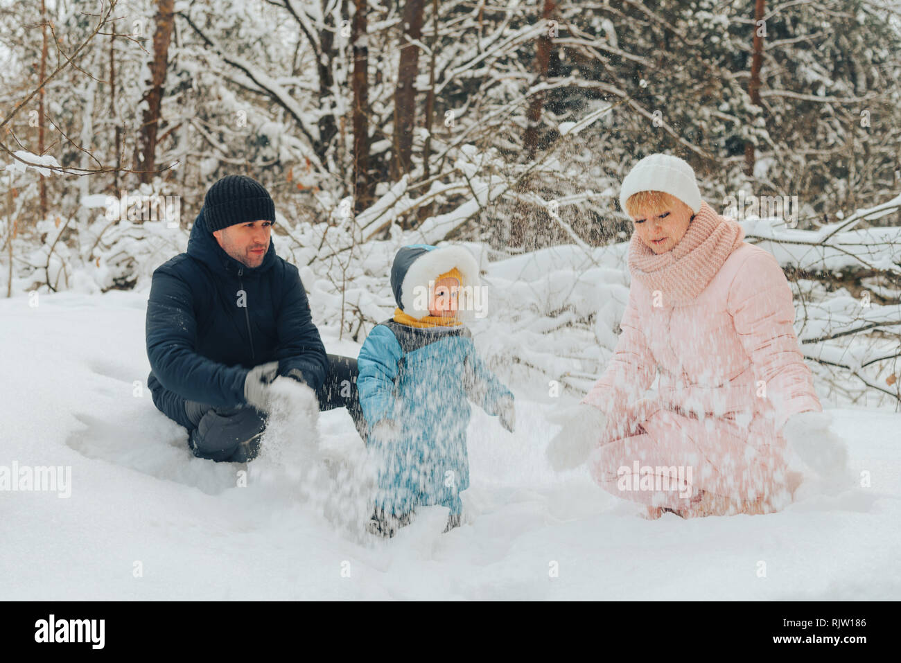 Famiglia a piedi con un bambino. La famiglia Passeggiate in natura in inverno. Famiglia inverno a piedi nella natura. Un sacco di neve. Boschi innevati. Foto Stock