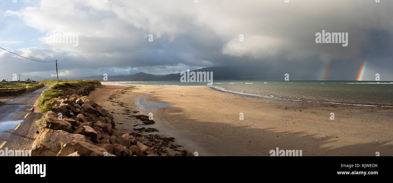 Un doppio arcobaleno e dark cloud pioggia sulla testa di Brandon dal Maharees, vicino a Castlegregory, penisola di Dingle, nella contea di Kerry, Irlanda Foto Stock