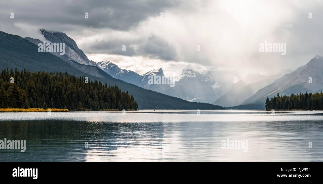 Il Lago Maligne, dietro la gamma della montagna di Queen Elizabeth gamme, cielo nuvoloso, Jasper National Park, montagne rocciose, Alberta, Canada Foto Stock