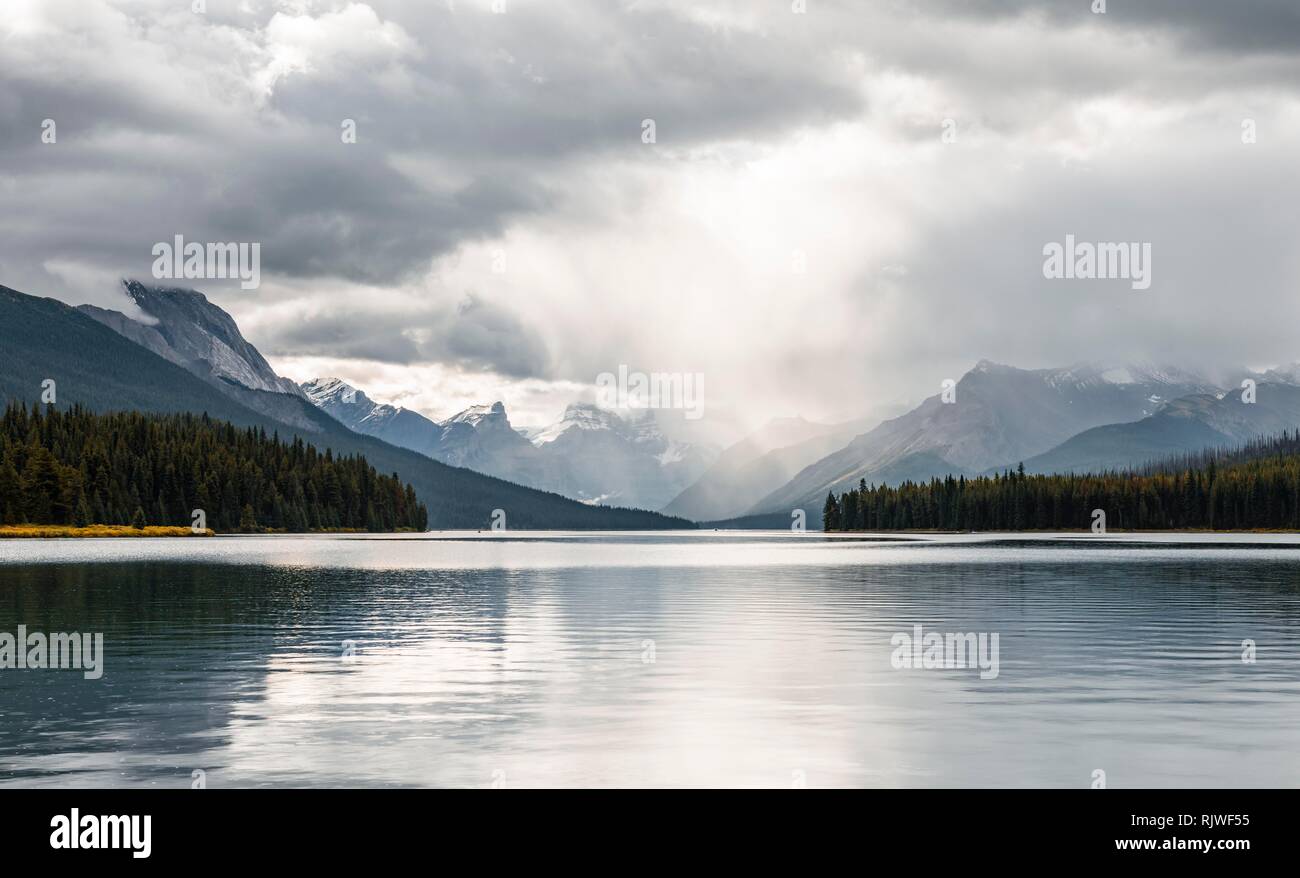 Il Lago Maligne, dietro la gamma della montagna di Queen Elizabeth gamme, cielo nuvoloso, Jasper National Park, montagne rocciose, Alberta, Canada Foto Stock