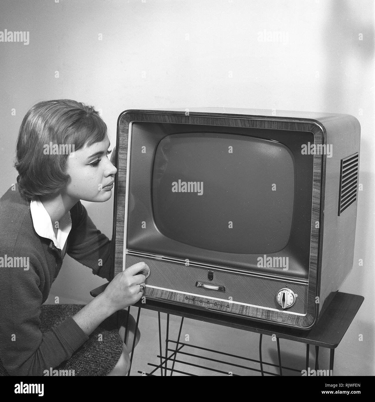 La televisione negli anni cinquanta. Una giovane donna è raffigurato  accanto a un tipico 50s televisore. Un tv Grundig in piedi su una tipica  stringa di metallo disossate tabella tv. Foto Kristoffersson