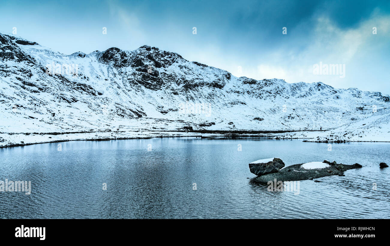 Vedute lungo il minatore della via verso il vertice di Y Wyddfa (Snowdon) su un nevoso, giornata invernale e. Foto Stock