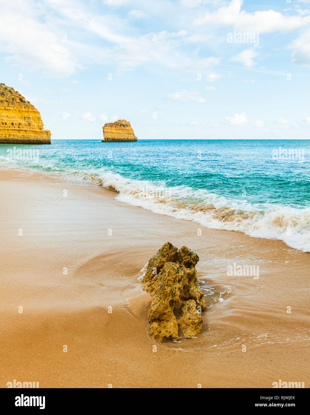 Sciabordare di onde in una spiaggia deserta e basso livello view, Praia da Marinha, Algarve, Portogallo, Europa Foto Stock