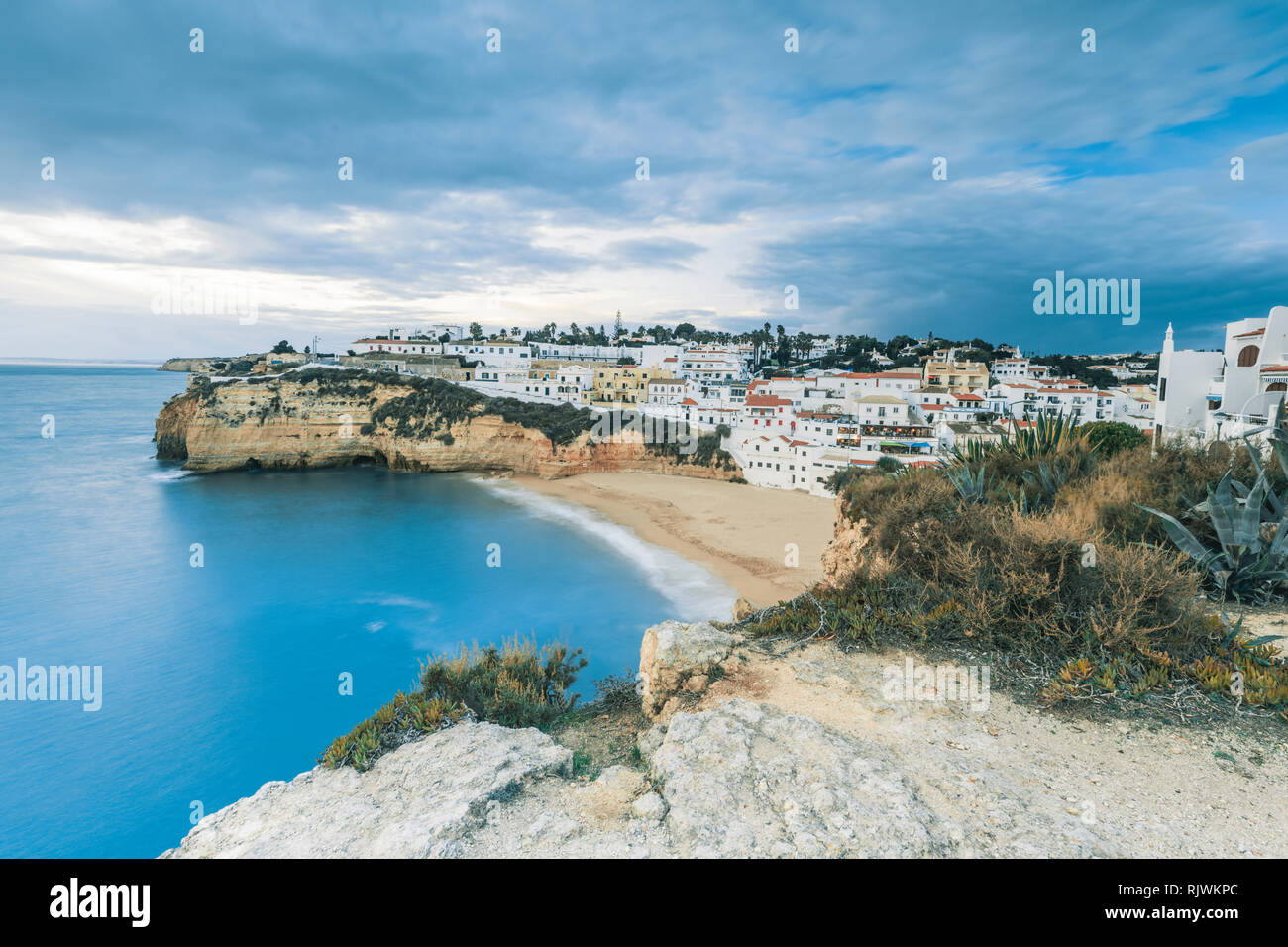 Cielo tempestoso sopra il villaggio e la spiaggia di sabbia, Carvoeiro, Algarve, Portogallo, Europa Foto Stock